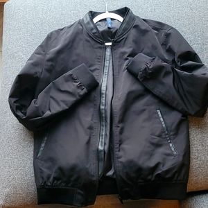 Jacket with elastic collar, long sleeves, and ribbed cuffs. Pockets at hip with